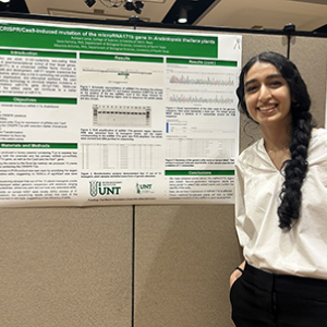 Ruhbani standing by poster during Scholars Day